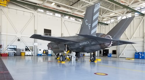 A gray Marine jet in an airplane hangar