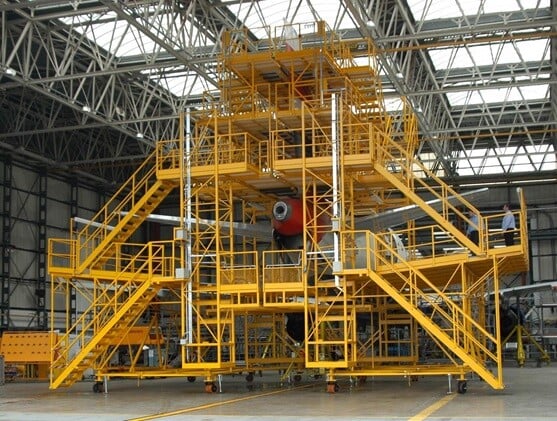 Yellow scaffolding surrounding a small airplane