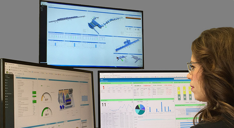 Woman sitting in front of a screen displaying IOPS (Input/Output Operations Per Second) monitoring data, with graphs and metrics visible on the screen.