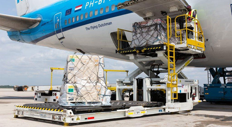 Ground equipment loading cargo onto airplane